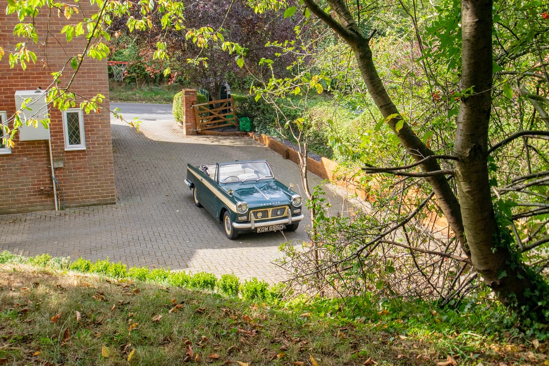 Green Triumph Herald convertible on a driveway